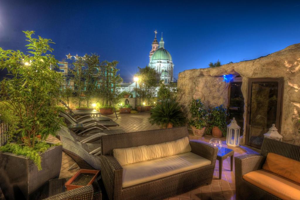 a patio with chairs and a building in the background at Hotel Palma in Pompei