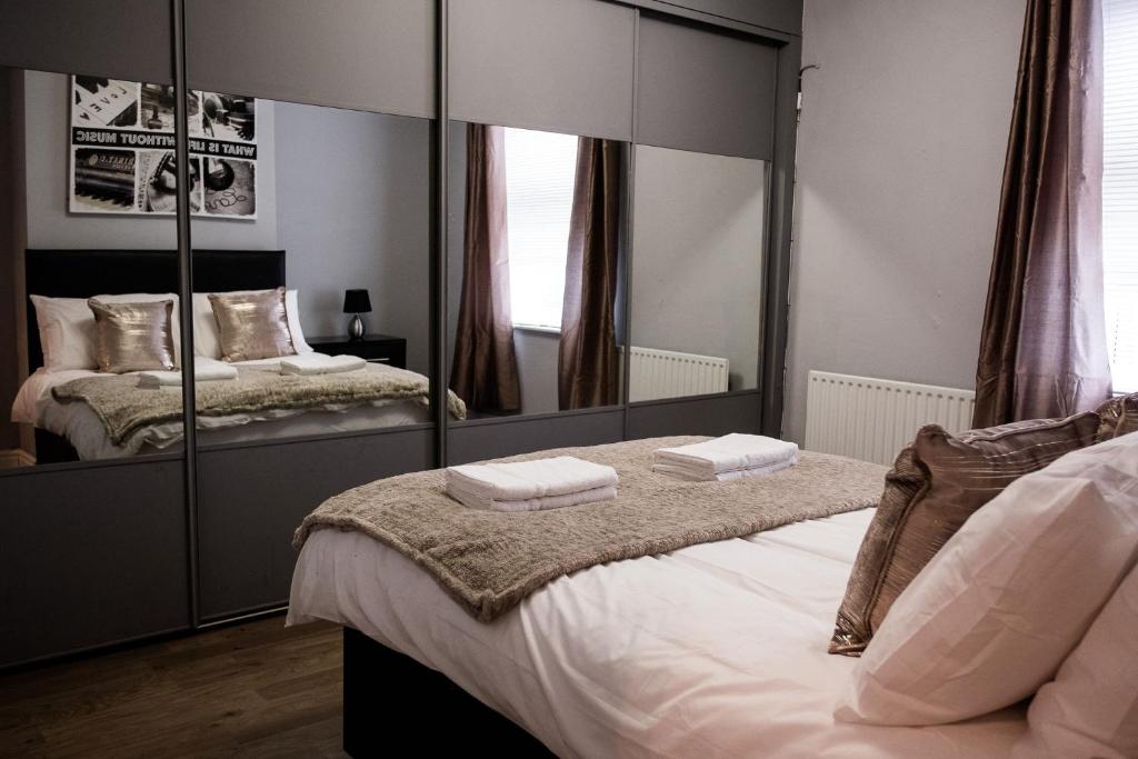 a bedroom with two beds and a large mirror at Inspired Stays- Close to City Centre- Sleeps up to 8 in Stoke on Trent