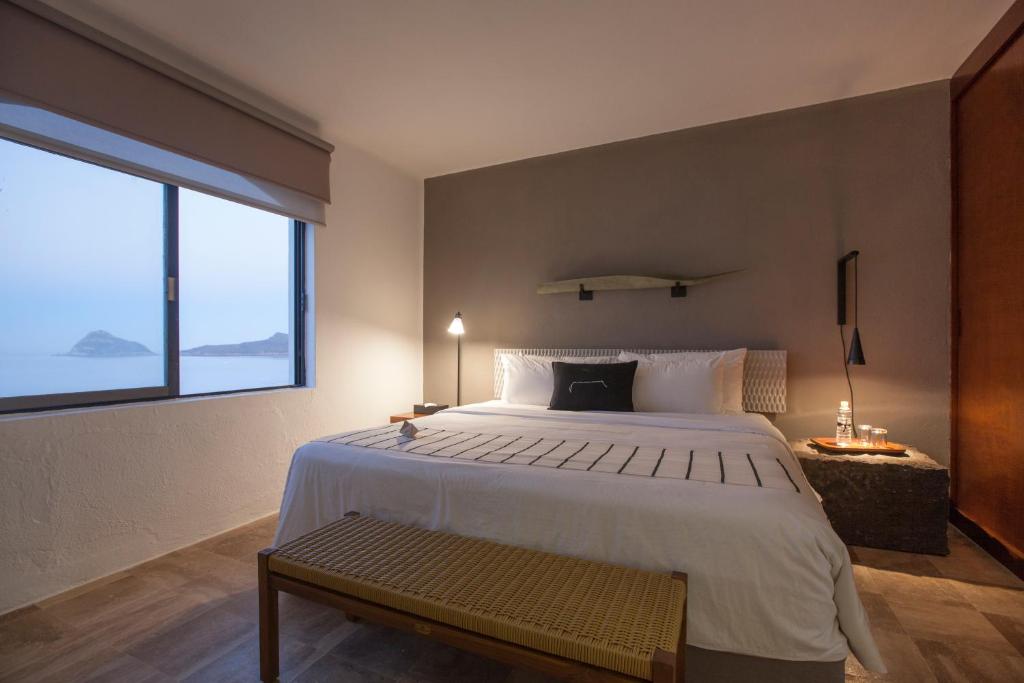 a bedroom with a large bed and a large window at Gaviana Resort in Mazatlán
