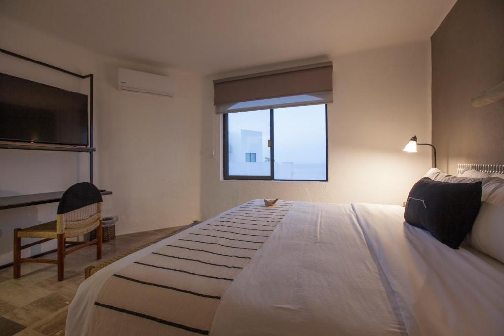 a bedroom with a large bed and a window at Gaviana Resort in Mazatlán