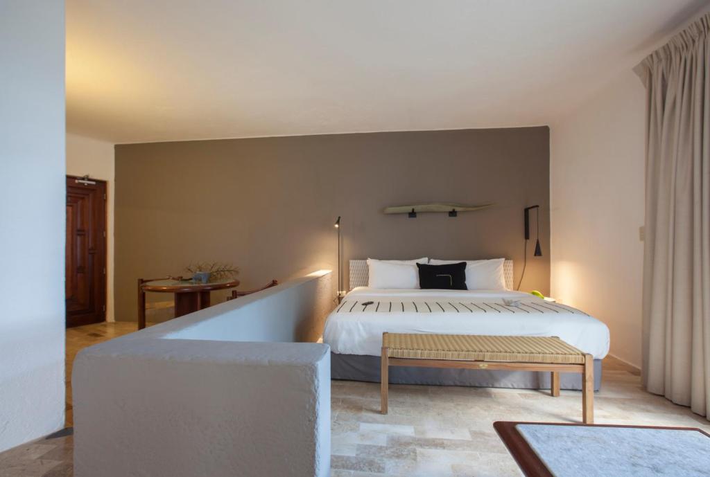 a bedroom with a large bed and a bench at Gaviana Resort in Mazatlán