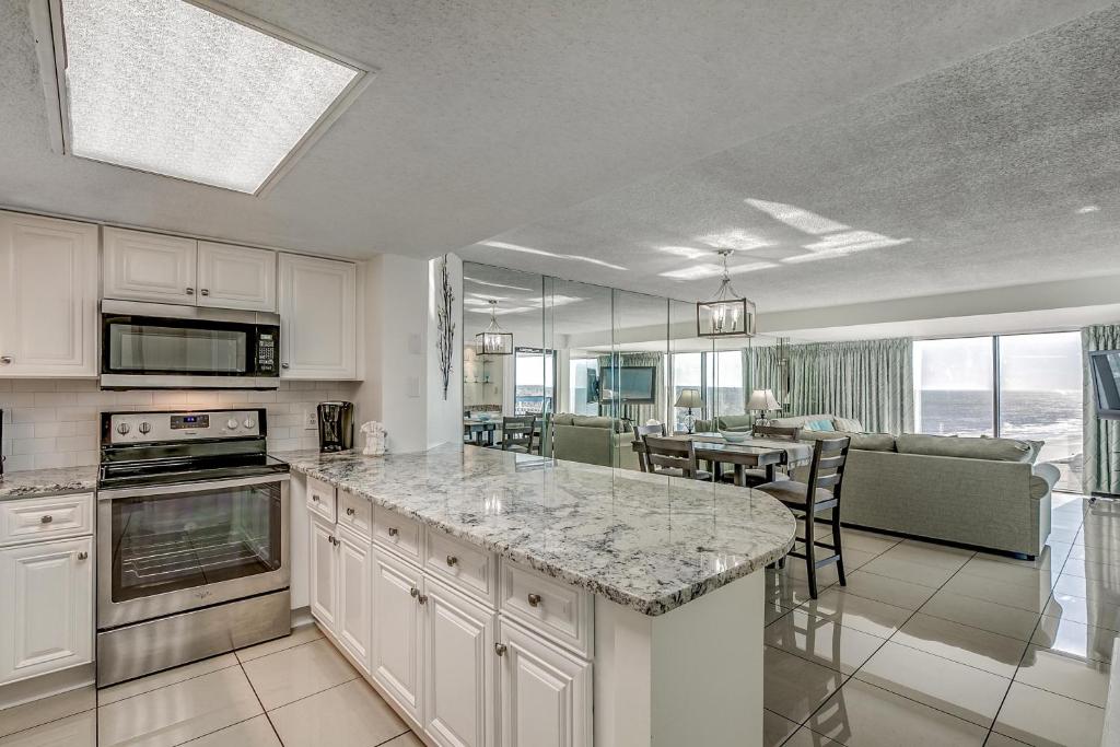 a kitchen with a counter top and a dining room at Forest Dunes Penthouse 1801 in Myrtle Beach