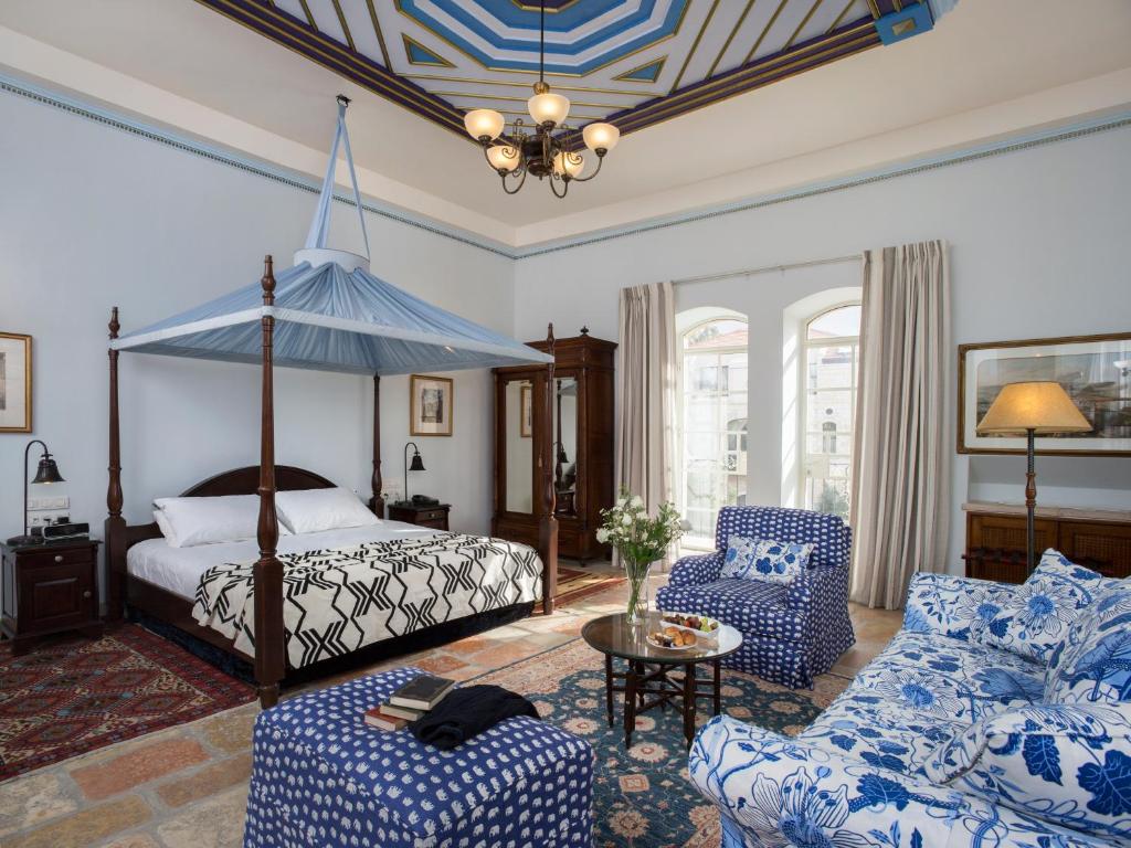 a bedroom with a canopy bed and blue and white furniture at The American Colony Hotel - Small Luxury Hotels of the World in Jerusalem