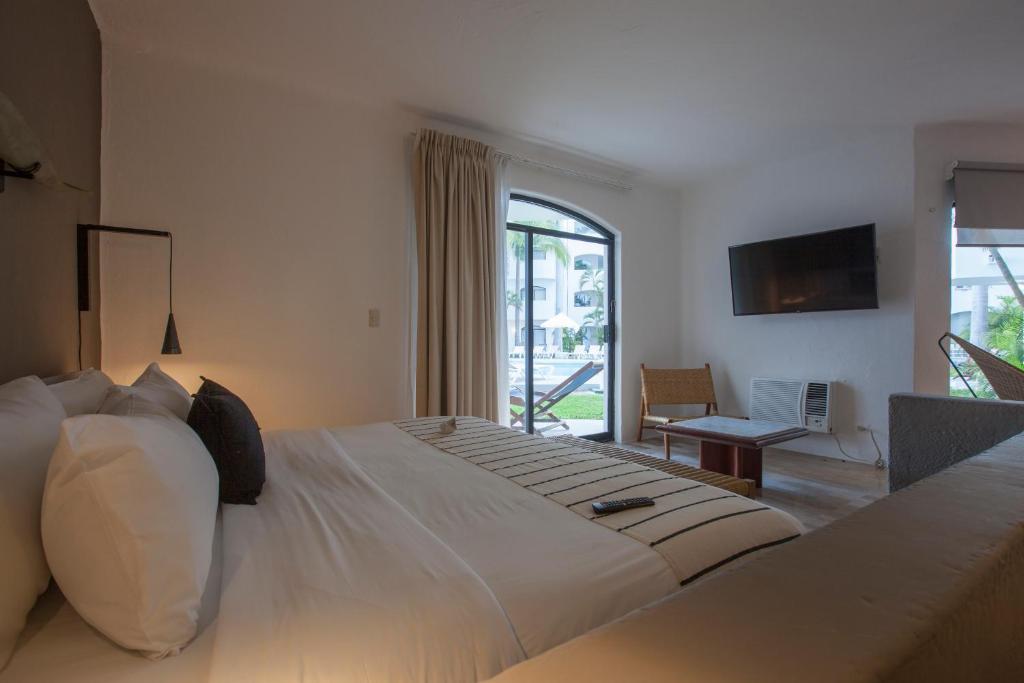 a bedroom with a large bed with a large window at Gaviana Resort in Mazatlán