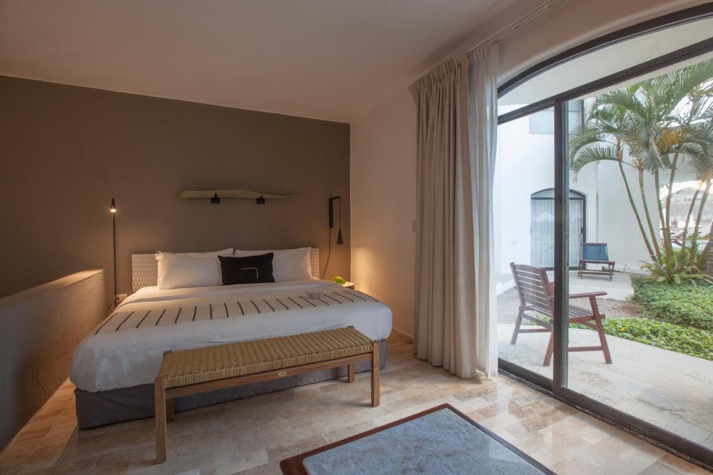 a bedroom with a large bed and a large window at Gaviana Resort in Mazatlán