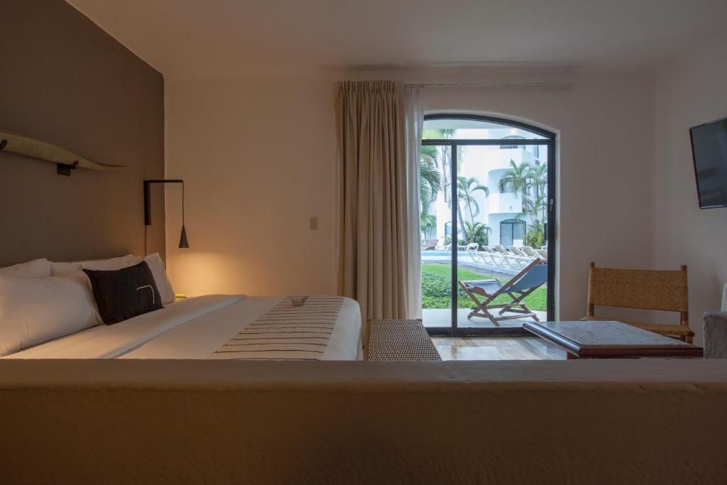 a bedroom with a bed and a door to a patio at Gaviana Resort in Mazatlán