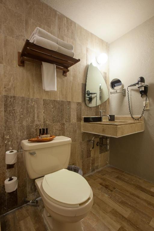 a bathroom with a toilet and a mirror at Gaviana Resort in Mazatlán