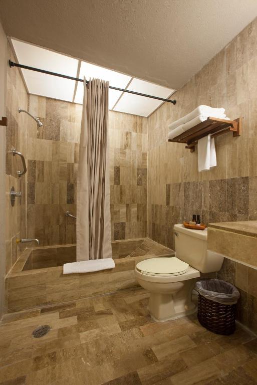 a bathroom with a tub and a toilet and a shower at Gaviana Resort in Mazatlán