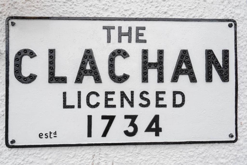 un cartel en una pared que lee el asharian con licencia en The Clachan Inn, en Drymen