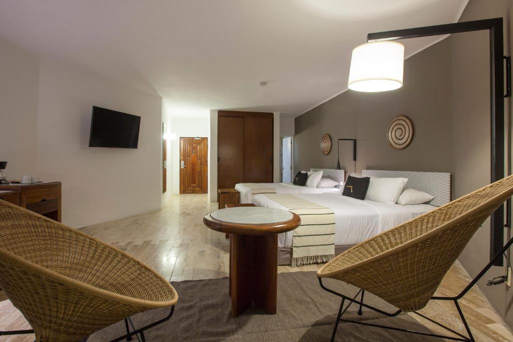 a hotel room with a bed and two chairs at Gaviana Resort in Mazatlán