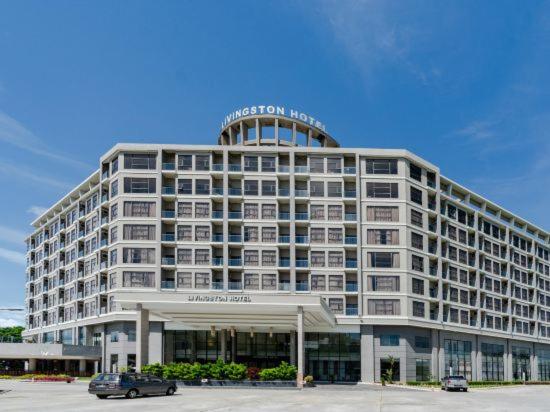 ein großes Gebäude mit einem davor geparkt in der Unterkunft Livingston Hotel in Sandakan