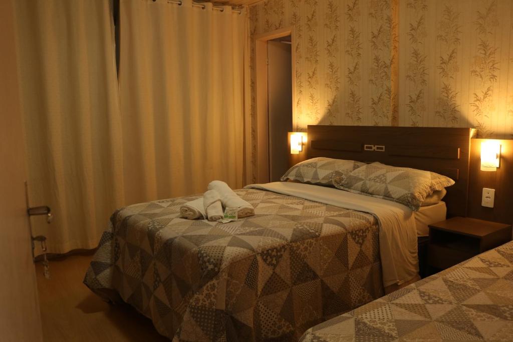 a hotel room with two beds with towels on them at Pousada Encantos da Serra in Bom Jardim da Serra