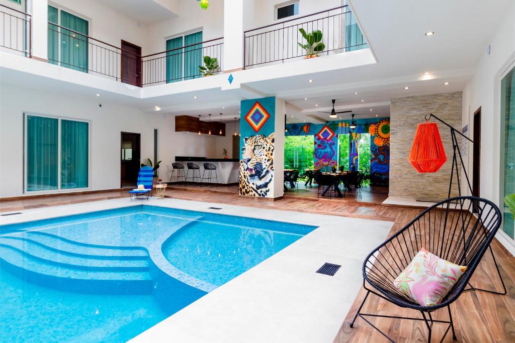 - une piscine dans une maison avec 2 chaises à côté dans l'établissement Riviera Sayulita Hotel, à Sayulita