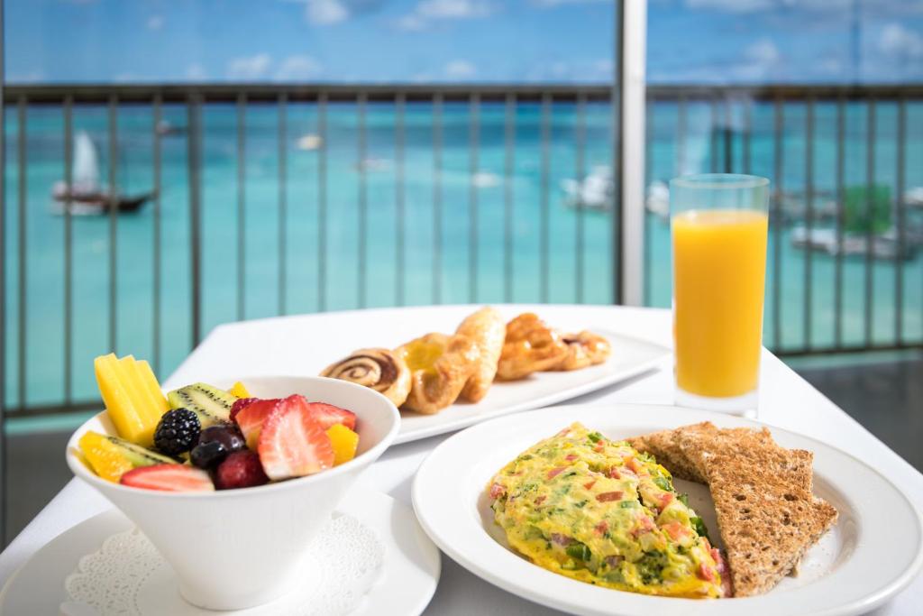 a table with a plate of breakfast food and a glass of orange juice at Holiday Inn Resort Aruba - Beach Resort & Casino, an IHG Hotel in Palm-Eagle Beach