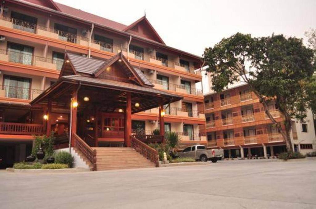 a large building with a staircase in front of it at Baankhun Chiang Mai Hotel in Chiang Mai