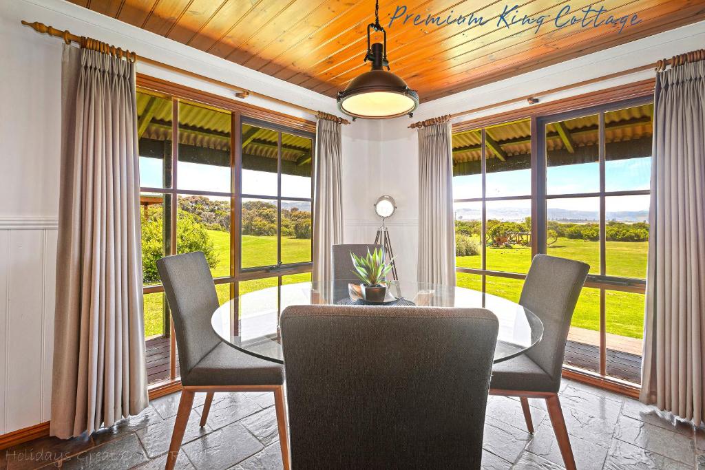 a living room with a table and chairs in it at Apollo Bay Cottages in Apollo Bay