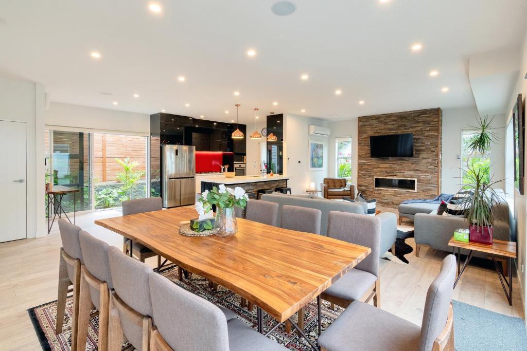 a dining room and living room with a wooden table and chairs at Elegant and Stylish Retreat in Leafy Epsom in Auckland