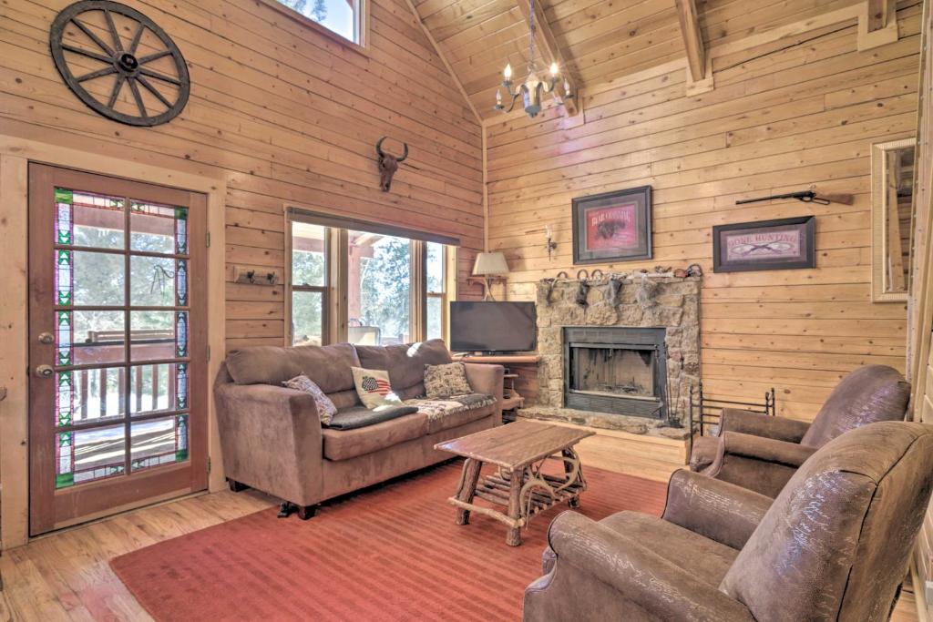 a living room with couches and a fireplace at Log Cabin with Mountain Views about 30 Mi to Pikes Peak! in Florissant