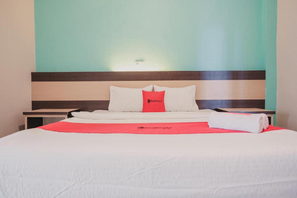 Postel nebo postele na pokoji v ubytování RedDoorz Syariah at Hotel Grand Mentari