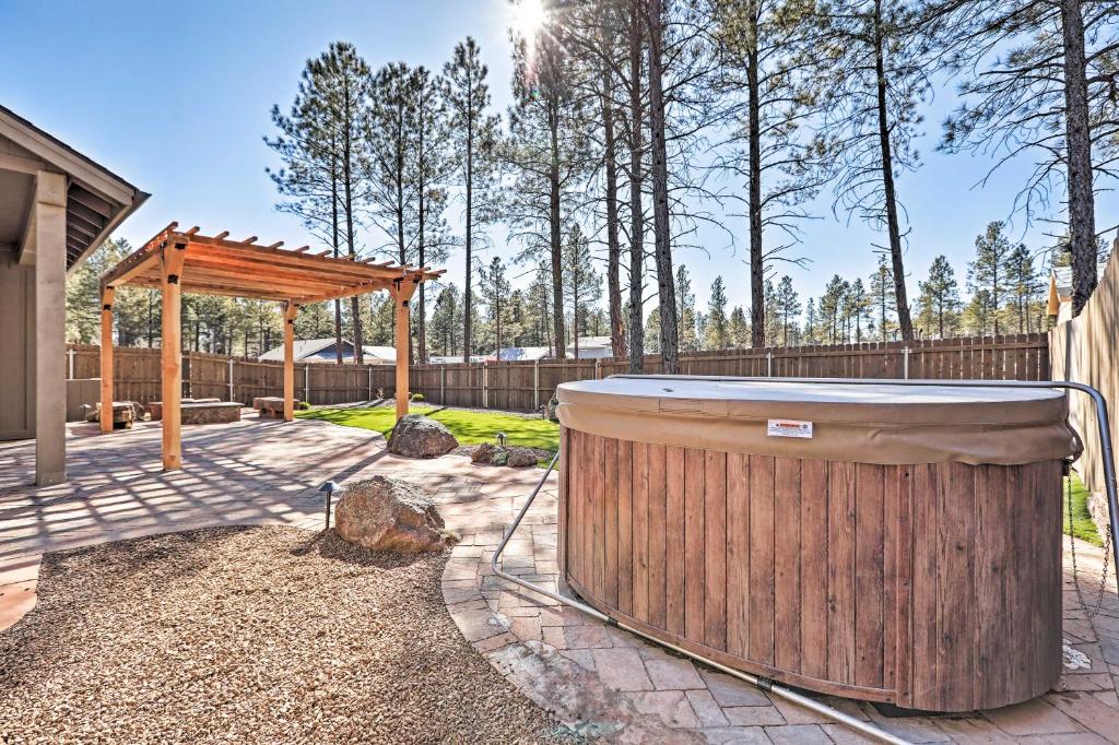 bañera de hidromasaje en un patio trasero con pérgola de madera en Flagstaff Oasis with Tesla Charger and Hot Tub!, en Flagstaff