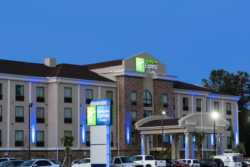 un hotel con coches estacionados en un estacionamiento en Holiday Inn Express and Suites Houston North - IAH Area, an IHG Hotel, en Houston
