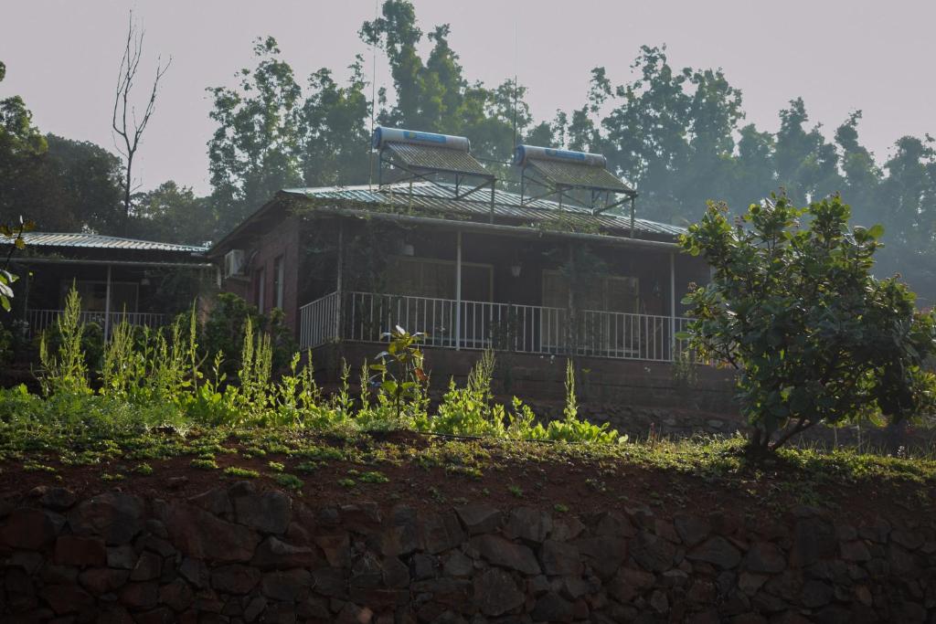 馬哈巴萊斯赫瓦爾的住宿－Jungle Valley Agriculture Resort，山丘上一座石墙房子