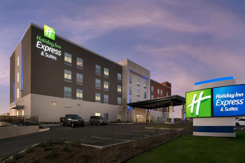 Holiday Inn Express & Suites San Antonio North-Windcrest, an IHG Hotel في سان انطونيو: فندق بمواقف السيارات امام مبنى
