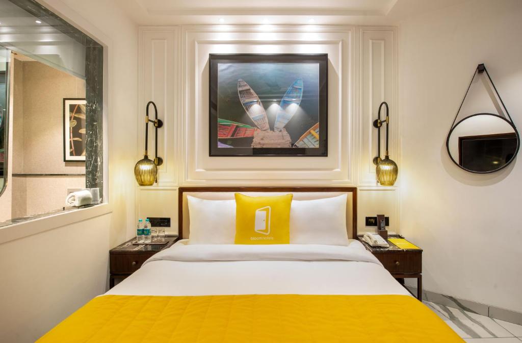 ein Schlafzimmer mit einem großen Bett und einer gelben Decke in der Unterkunft Bloom Boutique l GK-1 in Neu-Delhi