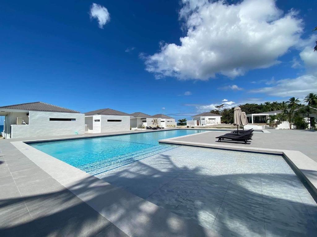 a swimming pool with two lounge chairs in a house at Cebu R Resort Tabuelan in Tabuelan