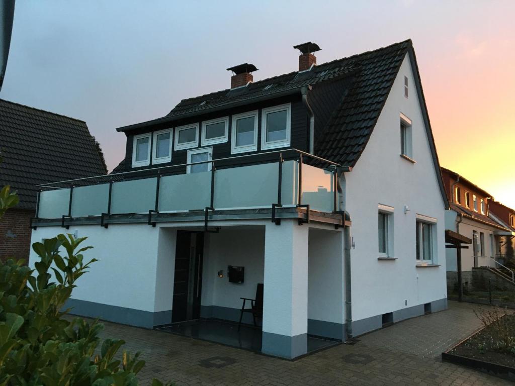 una casa blanca con techo negro en Ferienwohnung Rinteln - 4 Sterne - Im Kleinen Löök - 55 qm - 2 x TV - Terrasse - max 2 Erw und 1 Kind - Barrierearm TOP, en Rinteln