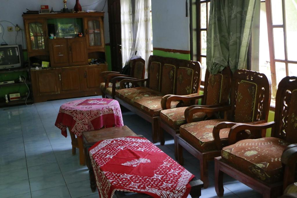 eine Gruppe von Stühlen mit roten Tischdecken in einem Zimmer in der Unterkunft Sri Homestay in Sermo