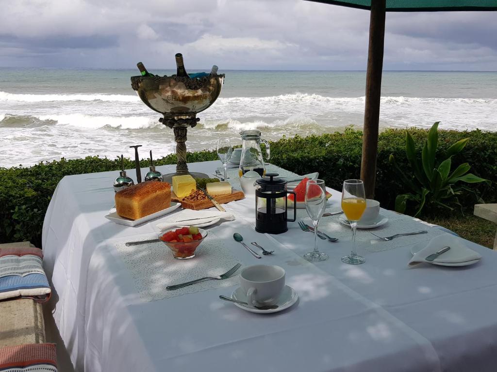 - une table avec de la nourriture et des boissons sur la plage dans l'établissement Tropical Beach Boutique Guesthouse, à Shelly Beach