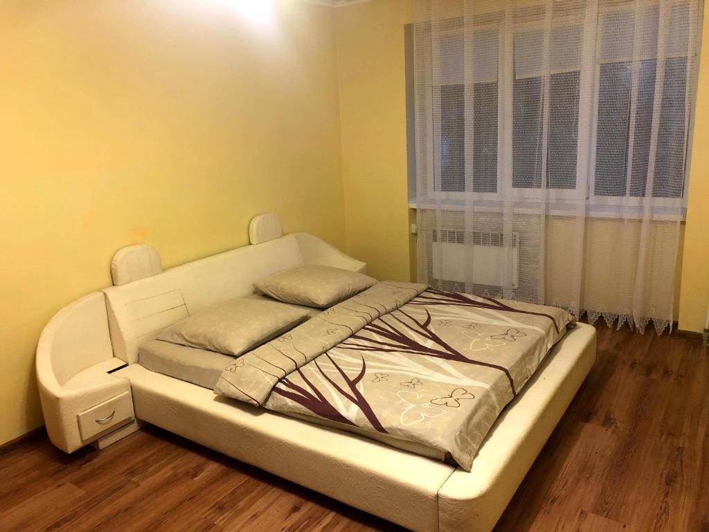 a white bed in a room with a window at GIL Apartments, Lermontova 1a, centre in Uzhhorod