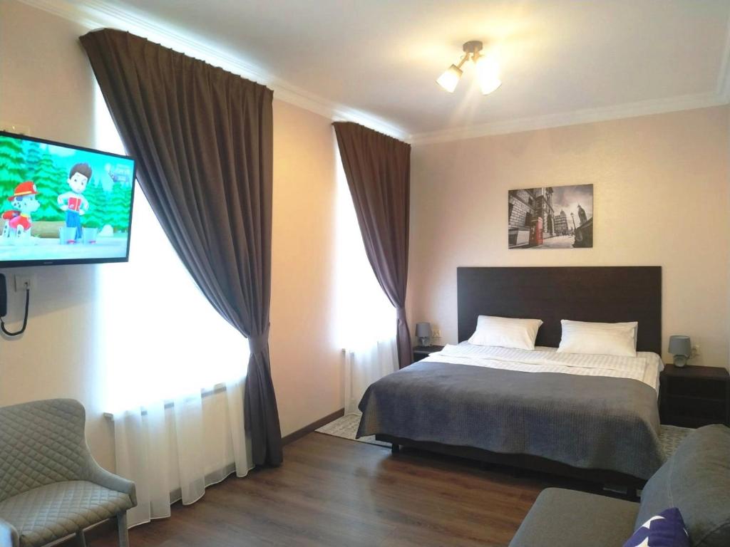 a bedroom with a bed and a flat screen tv at Hotel Business Apartments in Dnipro