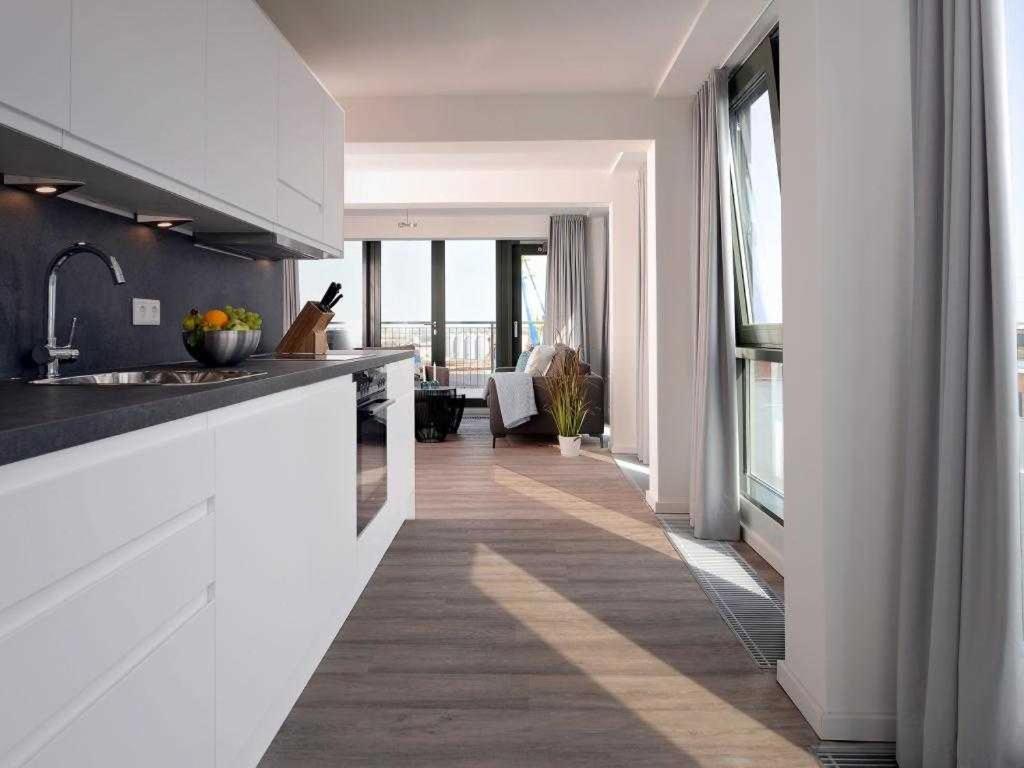 ヴィスマールにあるOhlerich Speicher App_ 47の白いキャビネットと大きな窓付きのキッチン