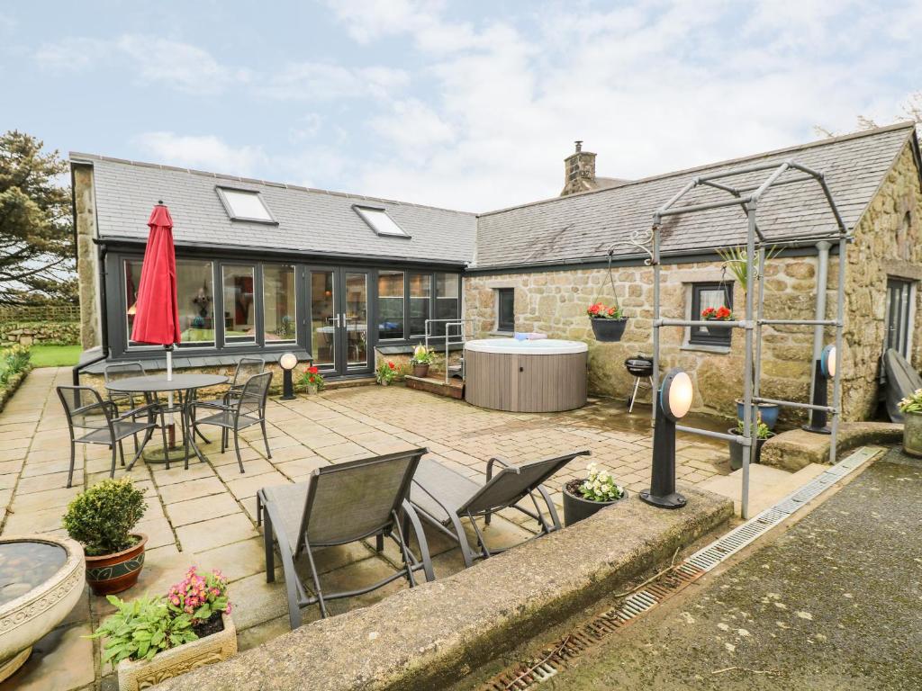 a house with a patio with a table and chairs at Meadowside in Penzance