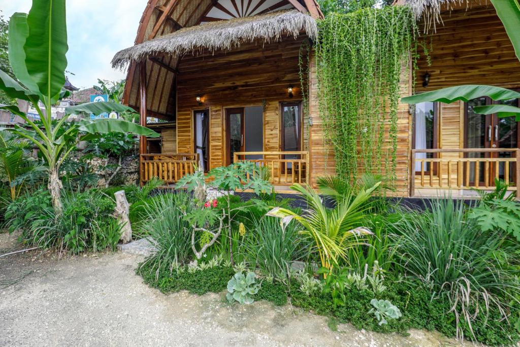 ein Blockhaus mit Pflanzen davor in der Unterkunft Indah Guest House Nusa Penida in Nusa Penida