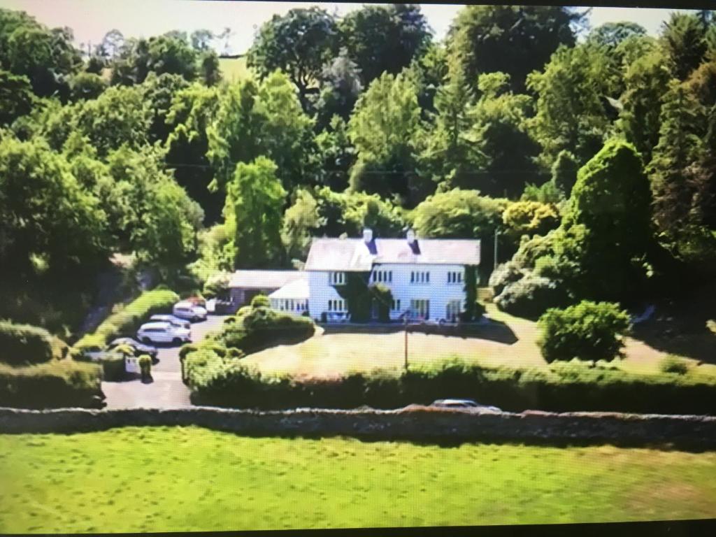 an aerial view of a white house in the forest at High Grassings Country House in Ambleside