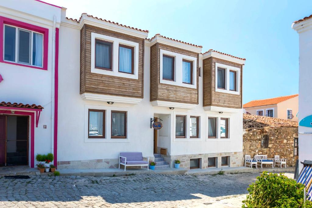 a house with a purple chair in front of it at Troas Ada Hotel in Bozcaada