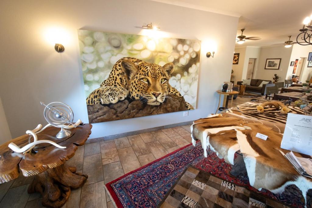 a room with a painting of a jaguar on the wall at The Serene Stay in Hoedspruit
