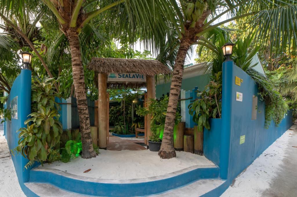 ein Resort mit Palmen vor einem Gebäude in der Unterkunft SeaLaVie Inn in Ukulhas