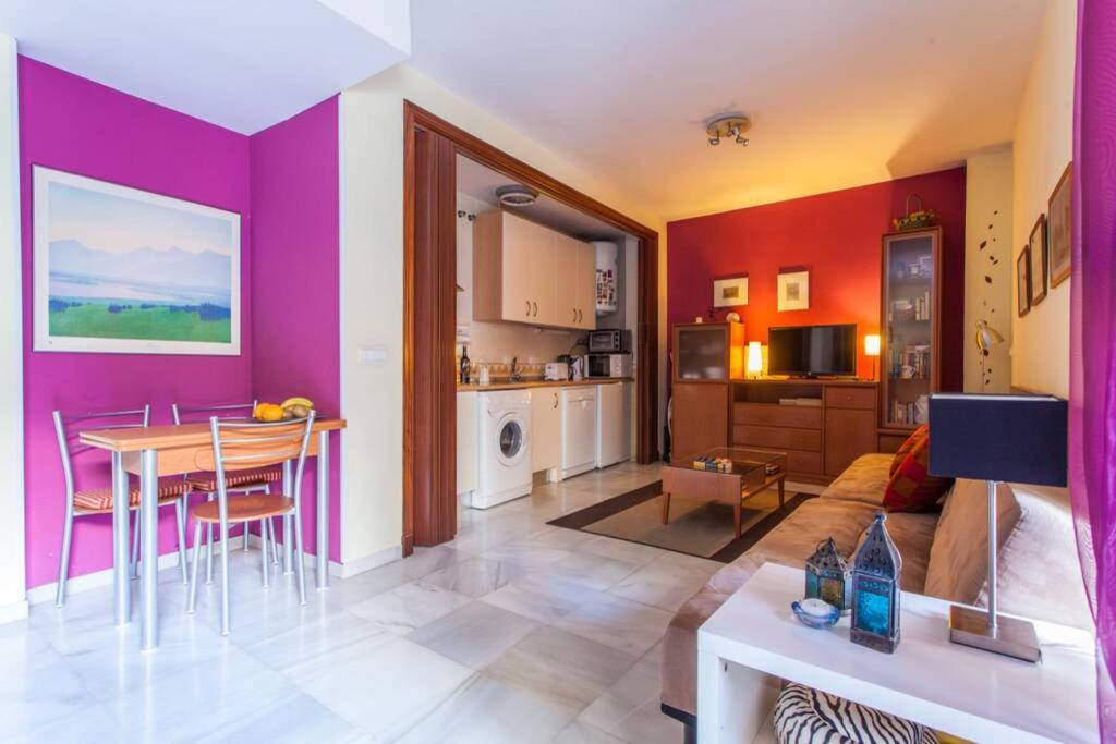a living room with a table and a kitchen at IMPECABLE APARTAMENTO EN TRIANA - SAN JACINTO in Seville