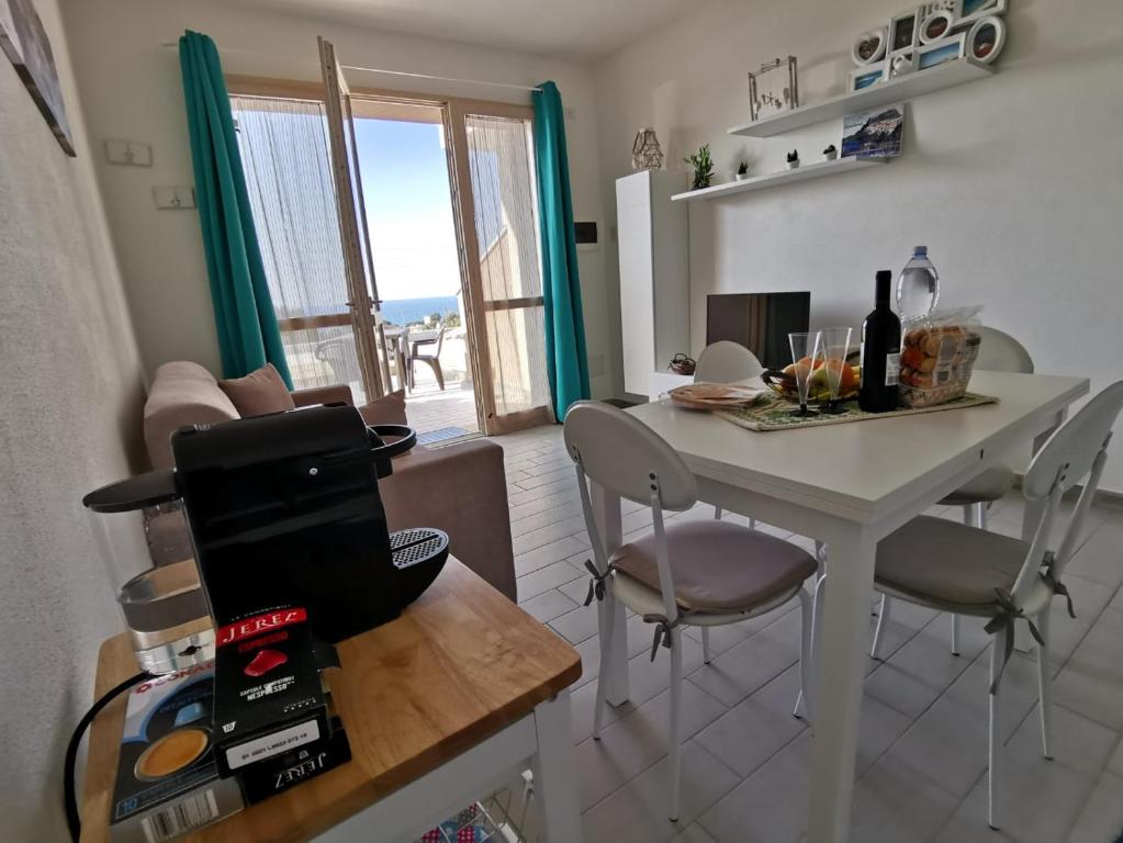 eine Küche mit einem Tisch und Stühlen mit Meerblick in der Unterkunft La Favola di Dani in Castelsardo