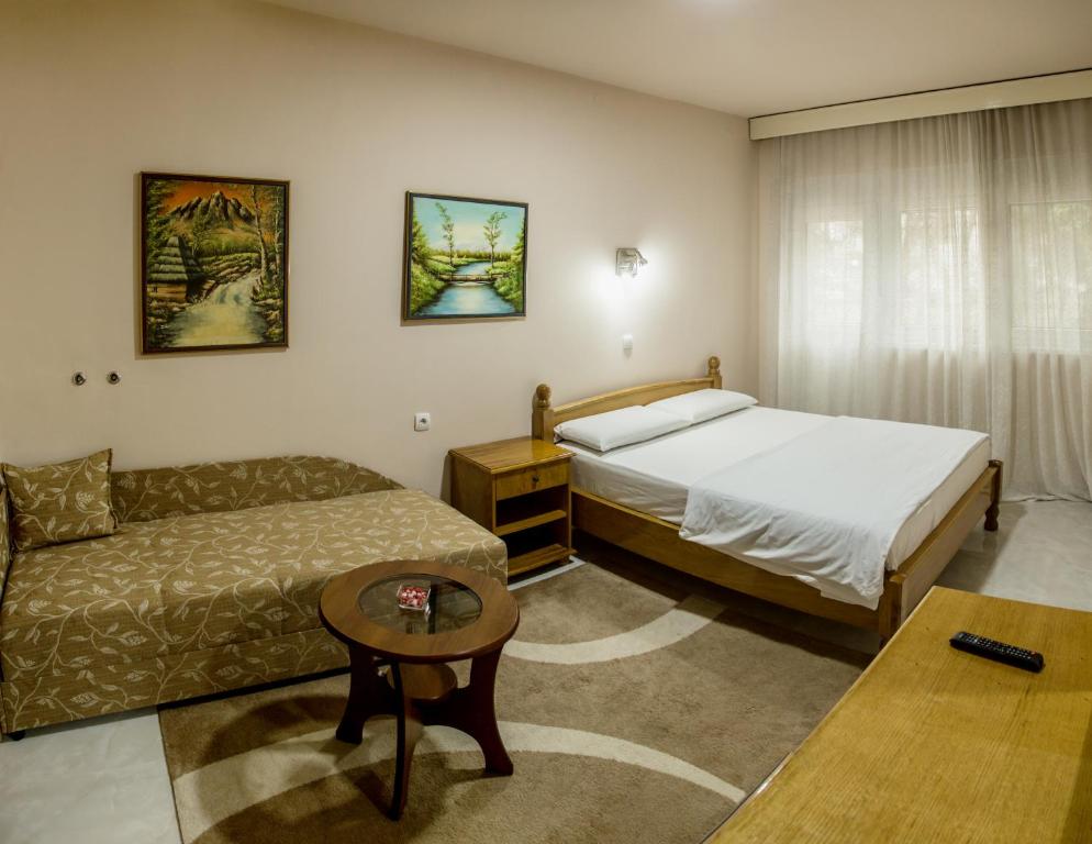 une chambre d'hôtel avec un lit et un canapé dans l'établissement B&B Passage, à Sremska Mitrovica