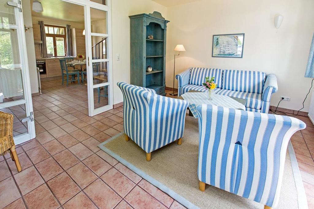 a living room with two chairs and a table at Ferienhaussiedlung Strandperlen Buchenhof 5a (Typ IV) in Wustrow