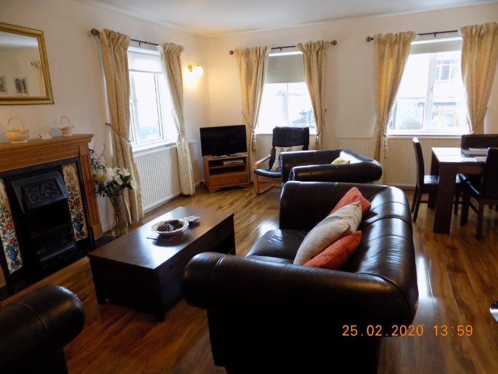 a living room with a leather couch and a table at Oakdene Apartments in Windermere