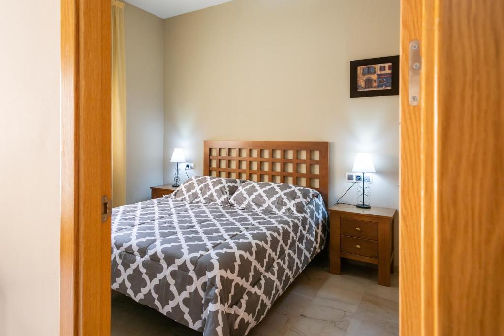 1 dormitorio con 1 cama y 2 mesas con lámparas en Apartamentos Turísticos La Castilleja, en Córdoba