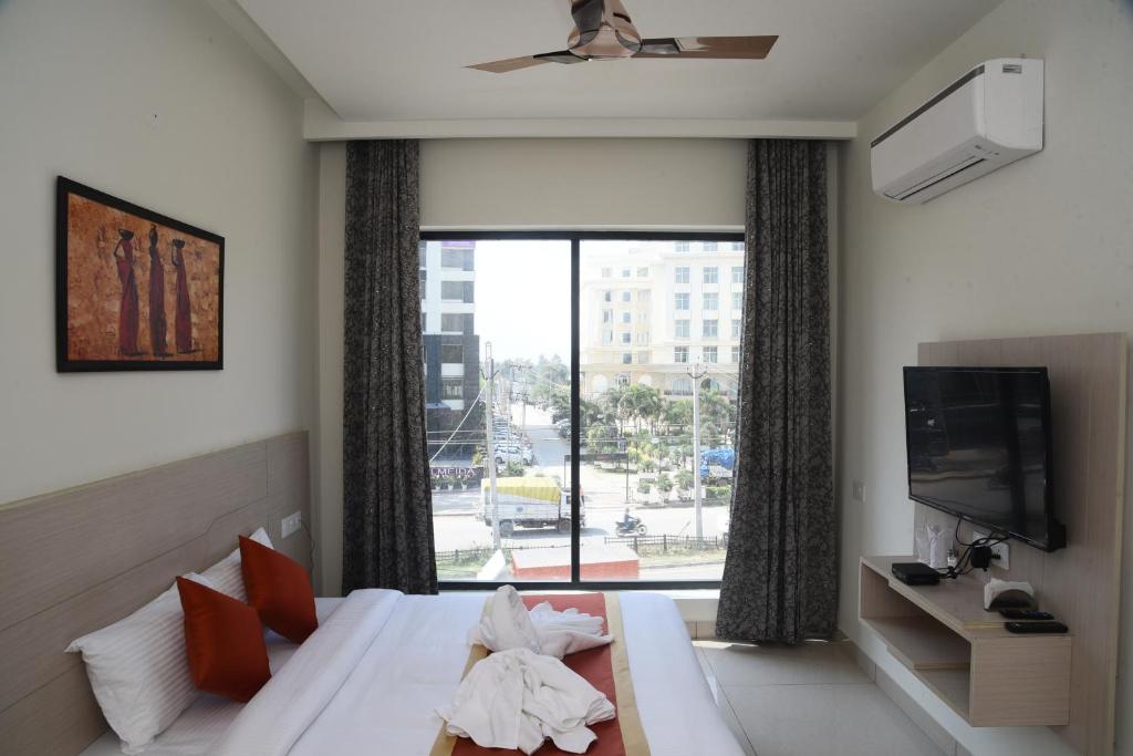 a hotel room with a bed and a large window at Hotel Hamilton in Zirakpur