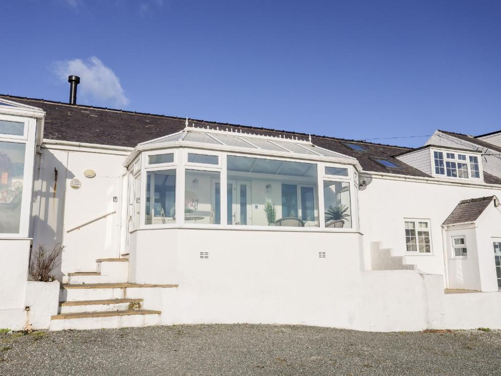 a white house with a large glass door at 5 Porthdafarch South Cottages in Holyhead