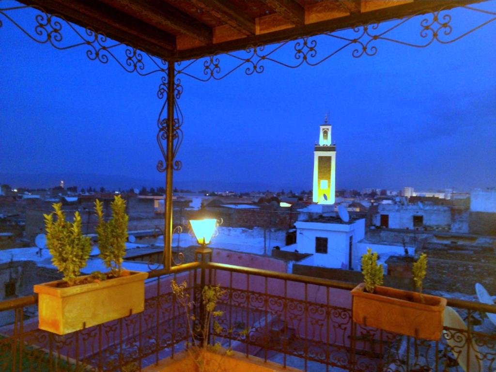 a view of a city at night with a clock tower at Riad Benchekroun in Meknès